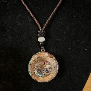 Evil eye amulet/ eye of Horus symbol with inlay of shell on a brown cord 28”